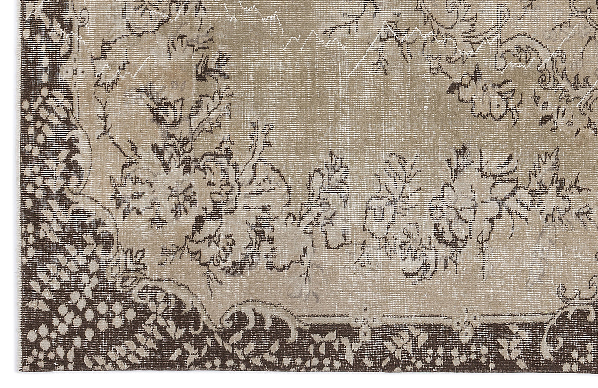 Distressed beige and dark brown rug with a traditional floral medallion pattern and a dense, stippled border.