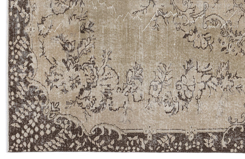 Load image 1 in gallery view. Distressed beige and dark brown rug with a traditional floral medallion pattern and a dense, stippled border.