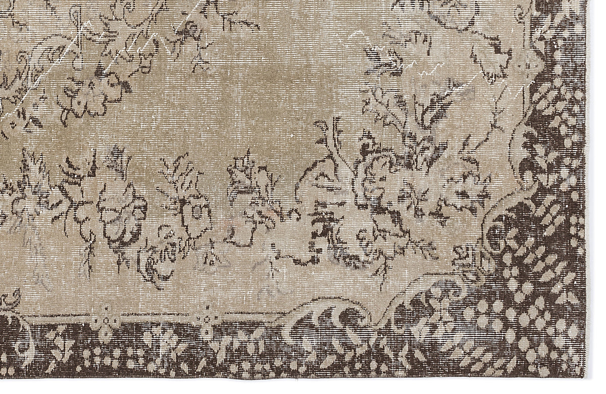 Distressed beige and dark brown rug with a traditional floral medallion pattern and a wide decorative border.