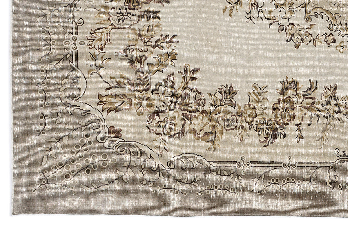 Beige and taupe vintage-style rug with a distressed floral medallion pattern and ornate border.