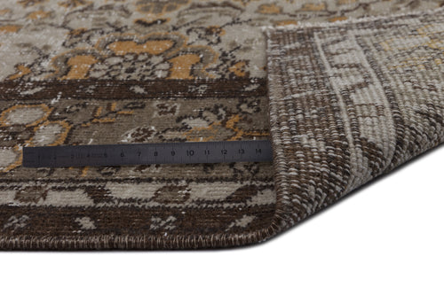 Load image 1 in gallery view. Brown, beige, and ochre traditional medallion rug with a folded corner and a metal ruler for scale.