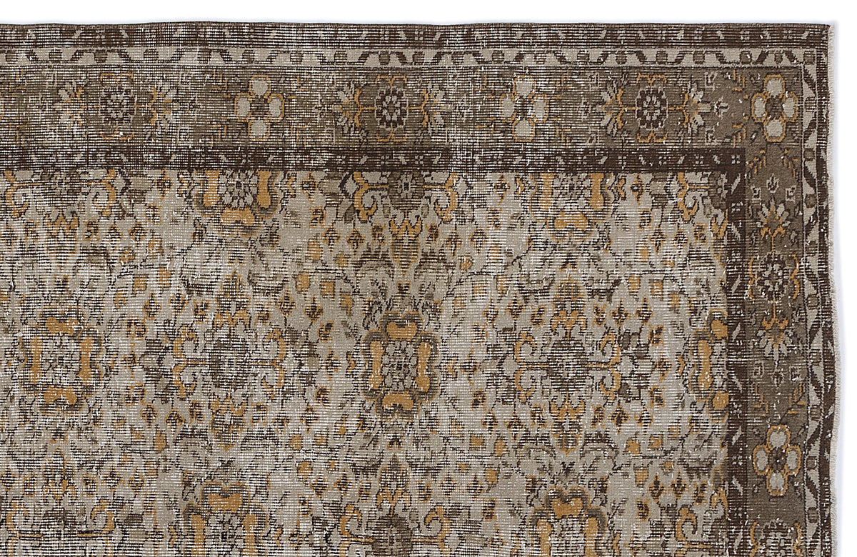 Brown, grey, and ochre traditional rug with a distressed floral medallion pattern and a detailed geometric border.