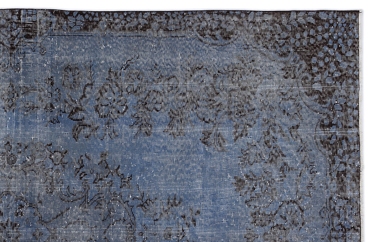 Distressed slate blue rug with a dark charcoal floral medallion pattern and a detailed border.