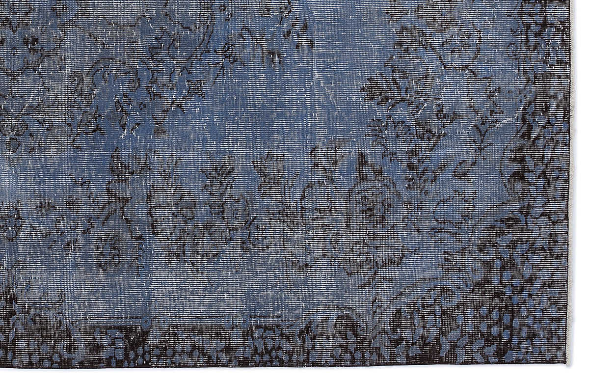 Blue and black distressed rug with a faded floral pattern and a dark border.
