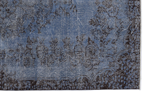 Load image 1 in gallery view. Blue and black distressed rug with a faded floral pattern and a dark border.