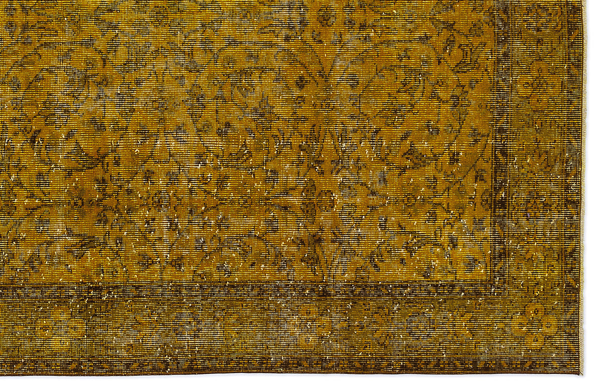 Mustard yellow vintage-style rug with a dark brown floral medallion pattern and a distressed border.