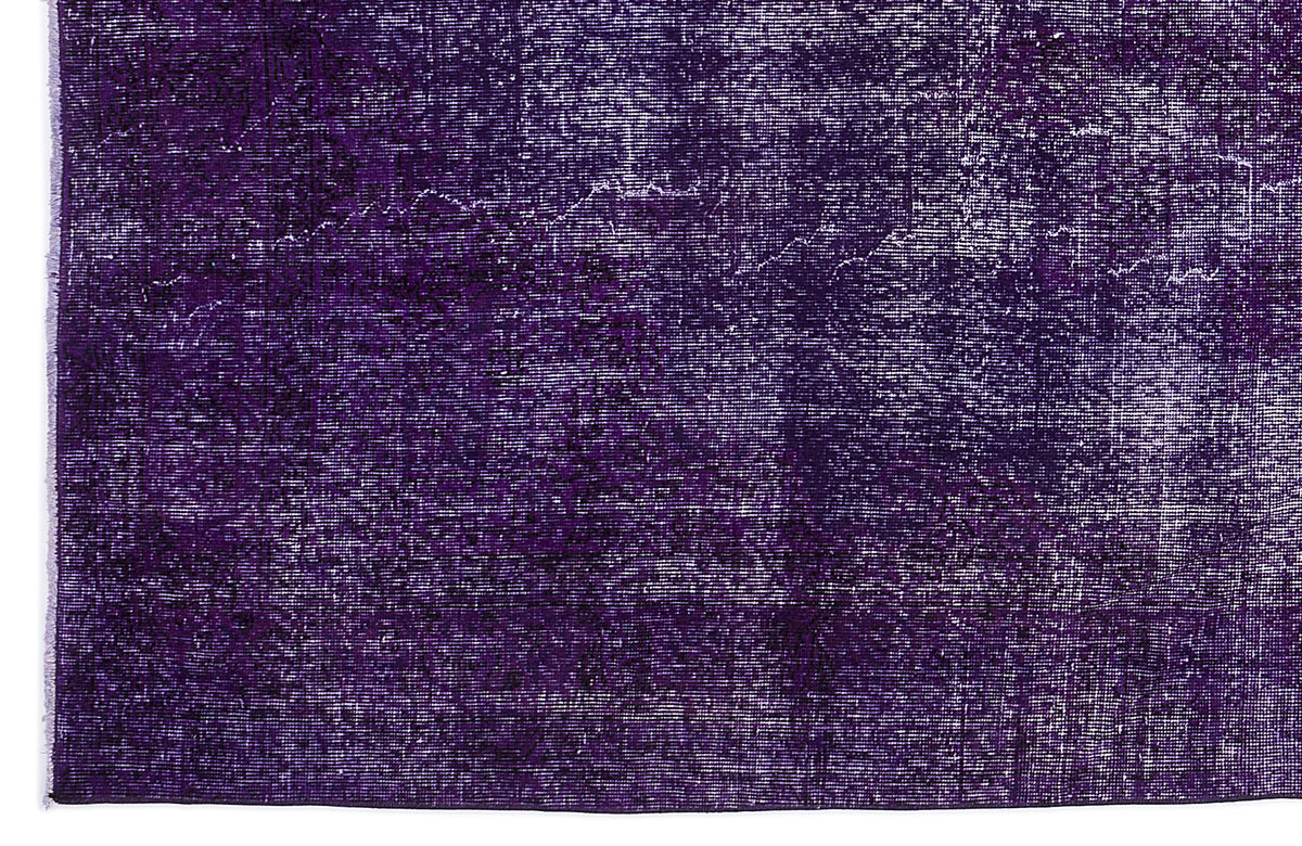 Deep purple vintage-style rug with a distressed, faded texture and subtle tonal medallion pattern.