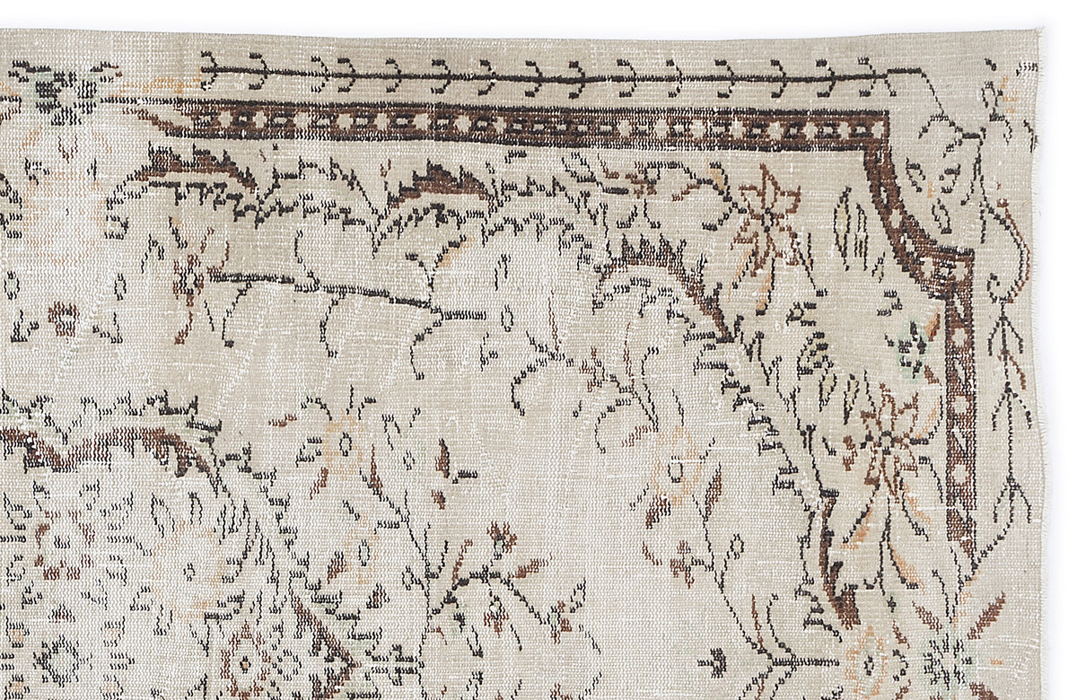 Beige vintage-style rug with a distressed brown and black floral border and central botanical motif.