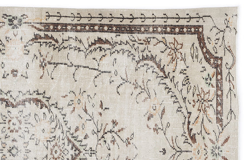 Load image 1 in gallery view. Beige vintage-style rug with a distressed brown and black floral border and central botanical motif.