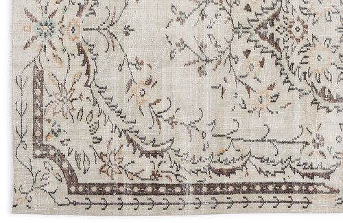 Load image 1 in gallery view. Beige rug with a distressed floral medallion pattern in brown, tan, and muted green accents.