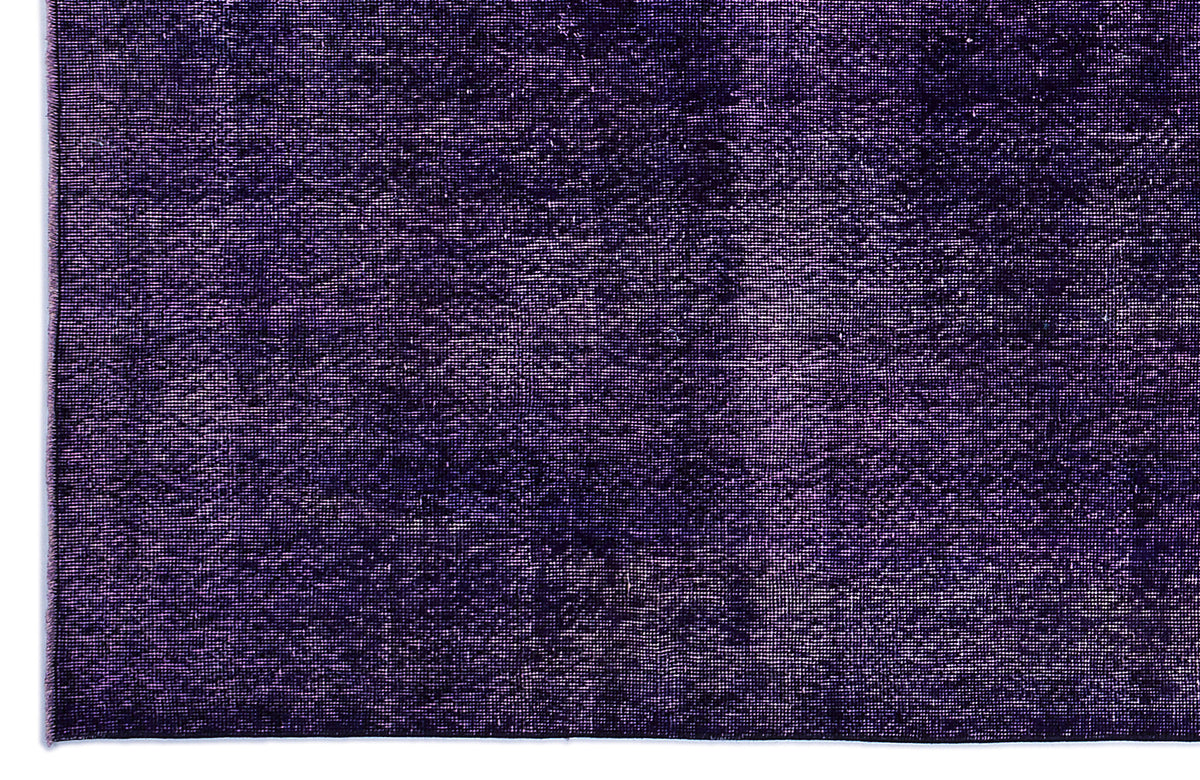 Deep purple rug with a distressed, monochromatic texture and a visible woven pile.