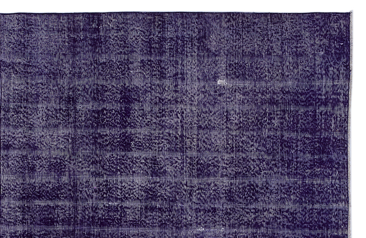 Deep purple rug with a distressed, overdyed texture and visible white woven base.