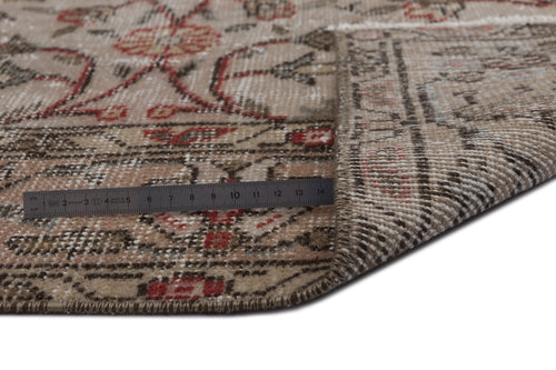 Load image 1 in gallery view. Beige and red traditional floral patterned rug with a folded corner and a metal ruler for scale.