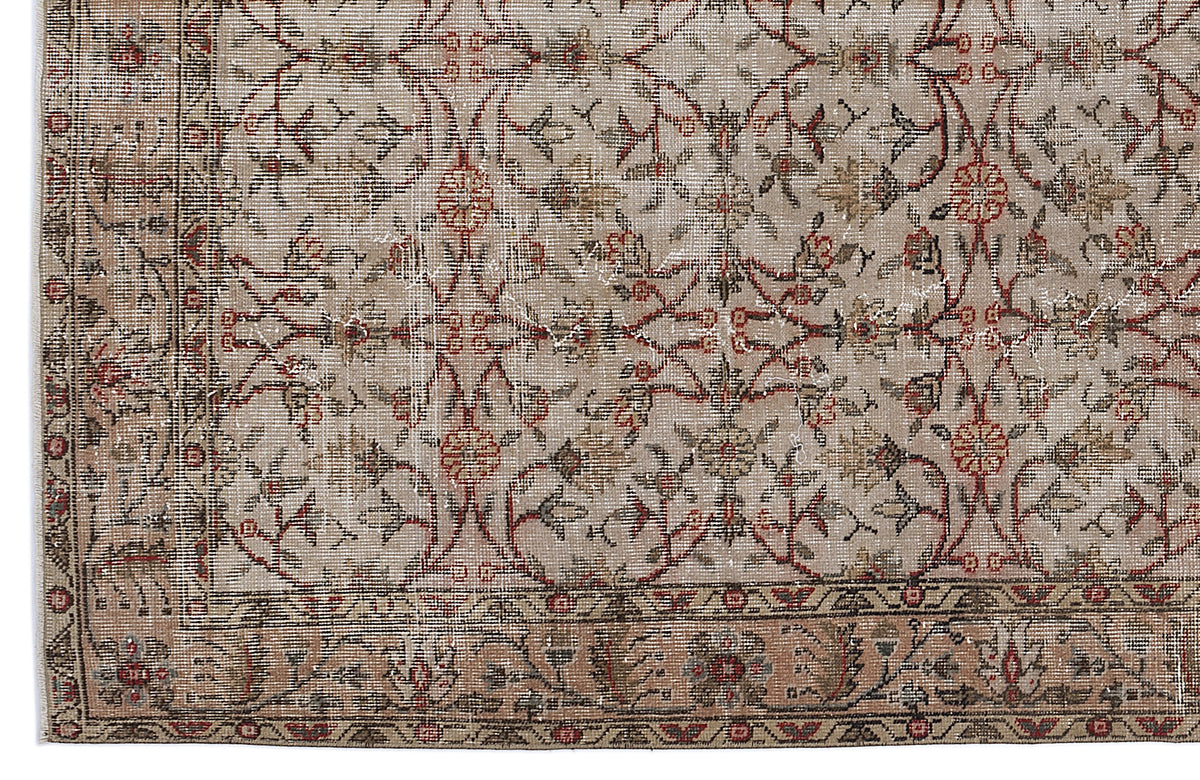 Beige and taupe vintage-style rug with a distressed floral vine pattern and a decorative border.