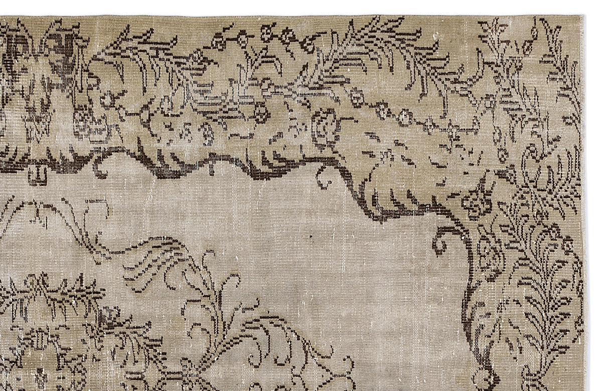 Distressed beige rug with a dark brown floral and vine pattern on a white background.