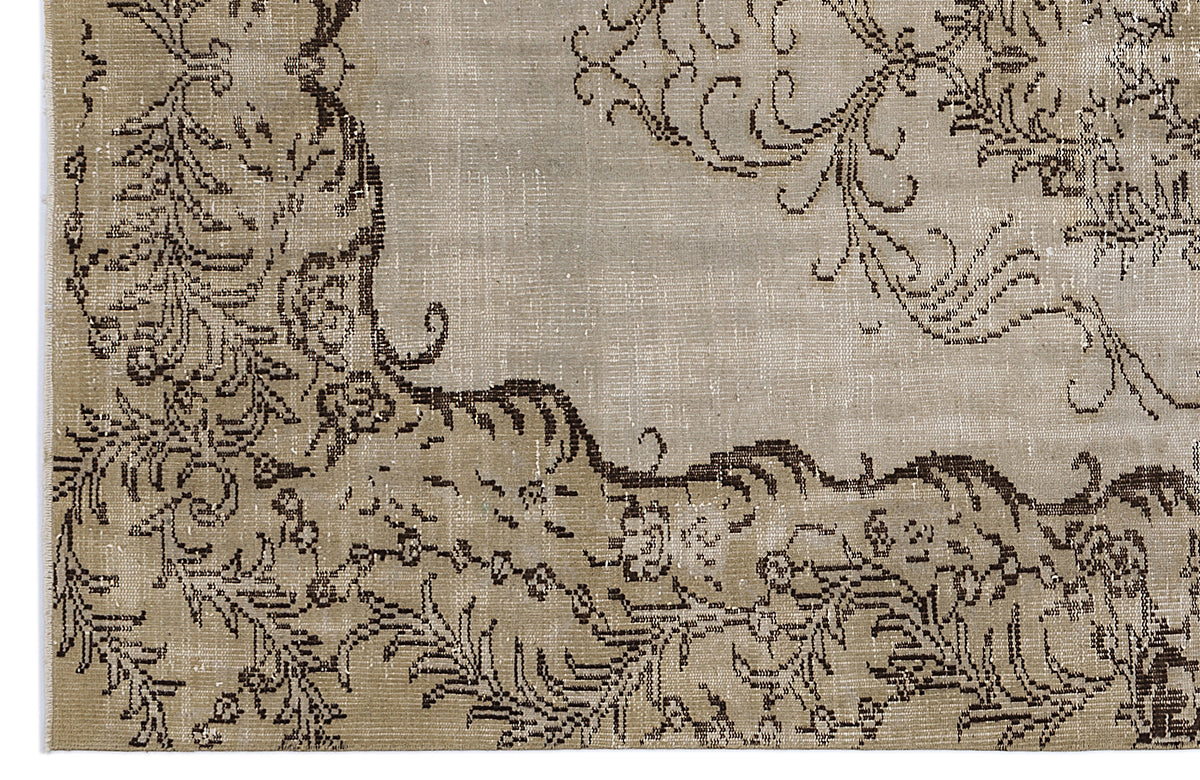 Taupe and dark brown distressed rug with an ornate, traditional floral medallion pattern.