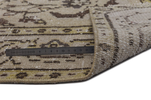Load image 1 in gallery view. Beige and brown traditional patterned rug with a folded corner and a metal ruler measuring the pile height.