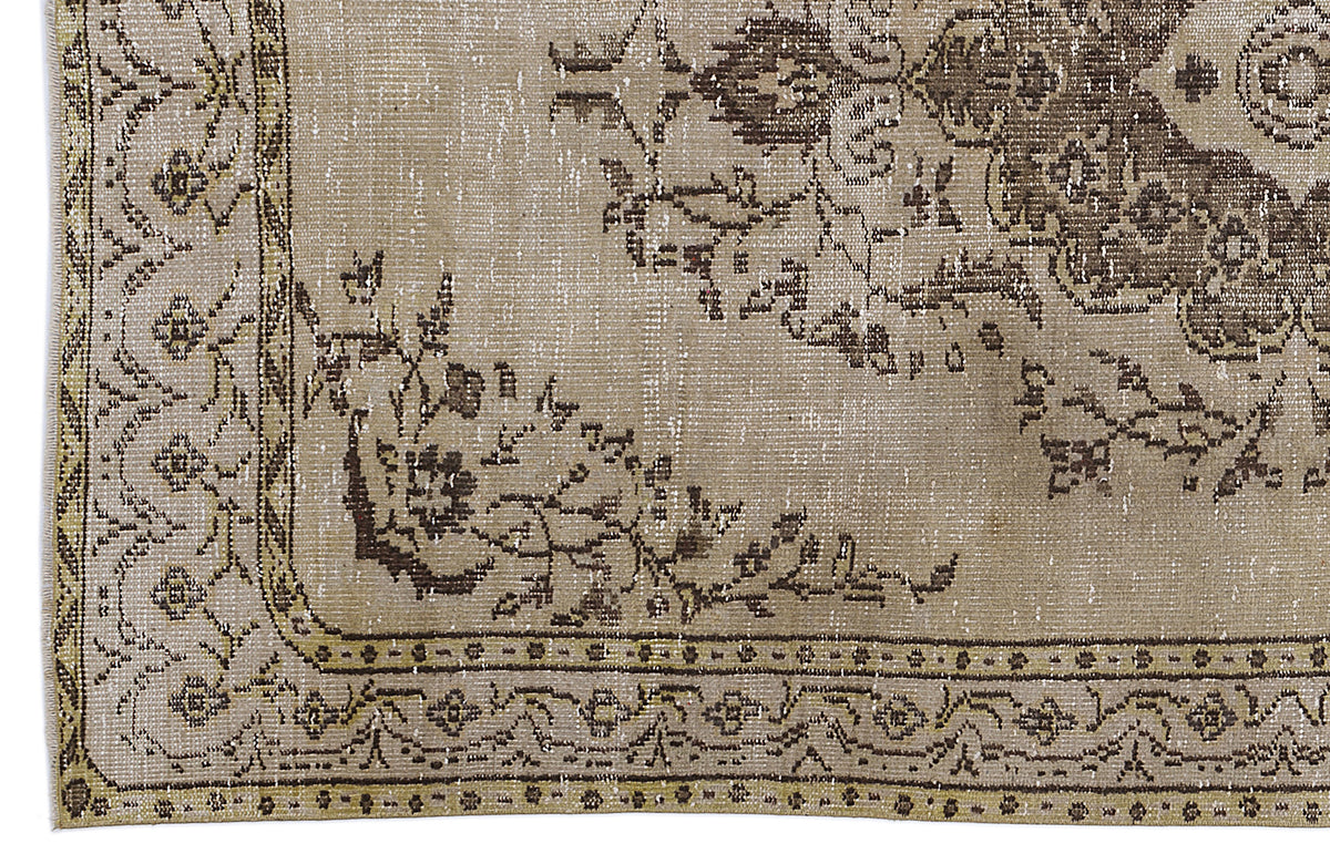 Distressed beige and brown rug with a traditional floral medallion pattern and an ornate geometric border.