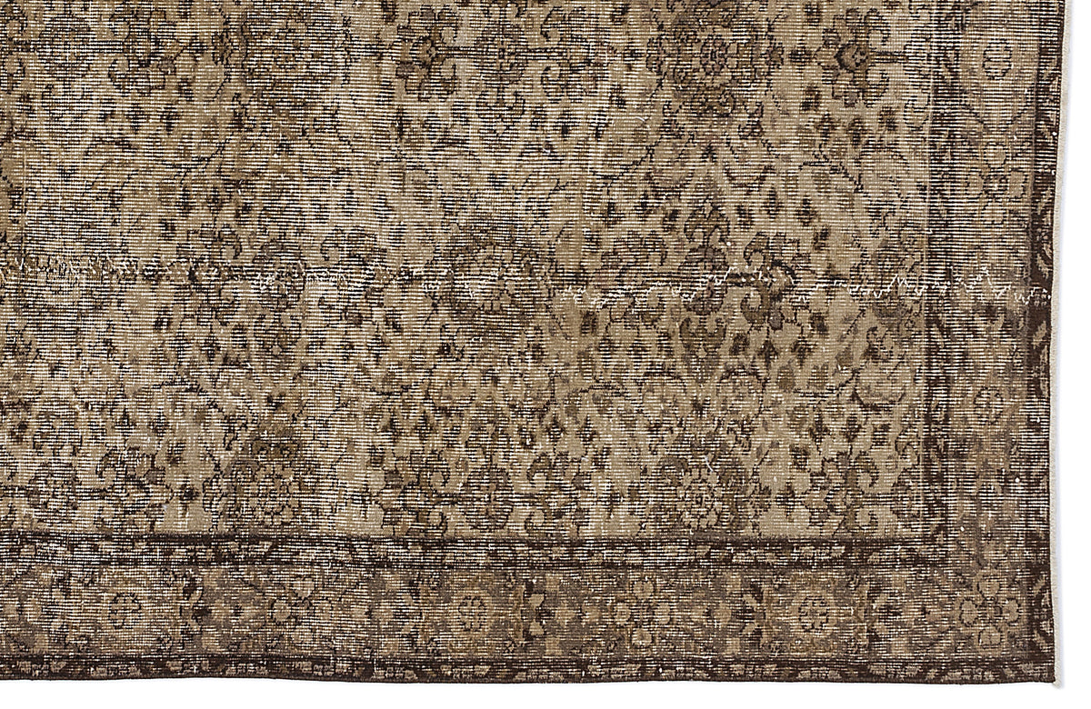 Brown and beige vintage-style rug with a distressed floral medallion pattern and a wide decorative border.