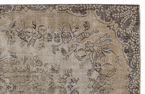 Load image 1 in gallery view. Distressed brown and beige vintage-style rug with a traditional floral medallion pattern.