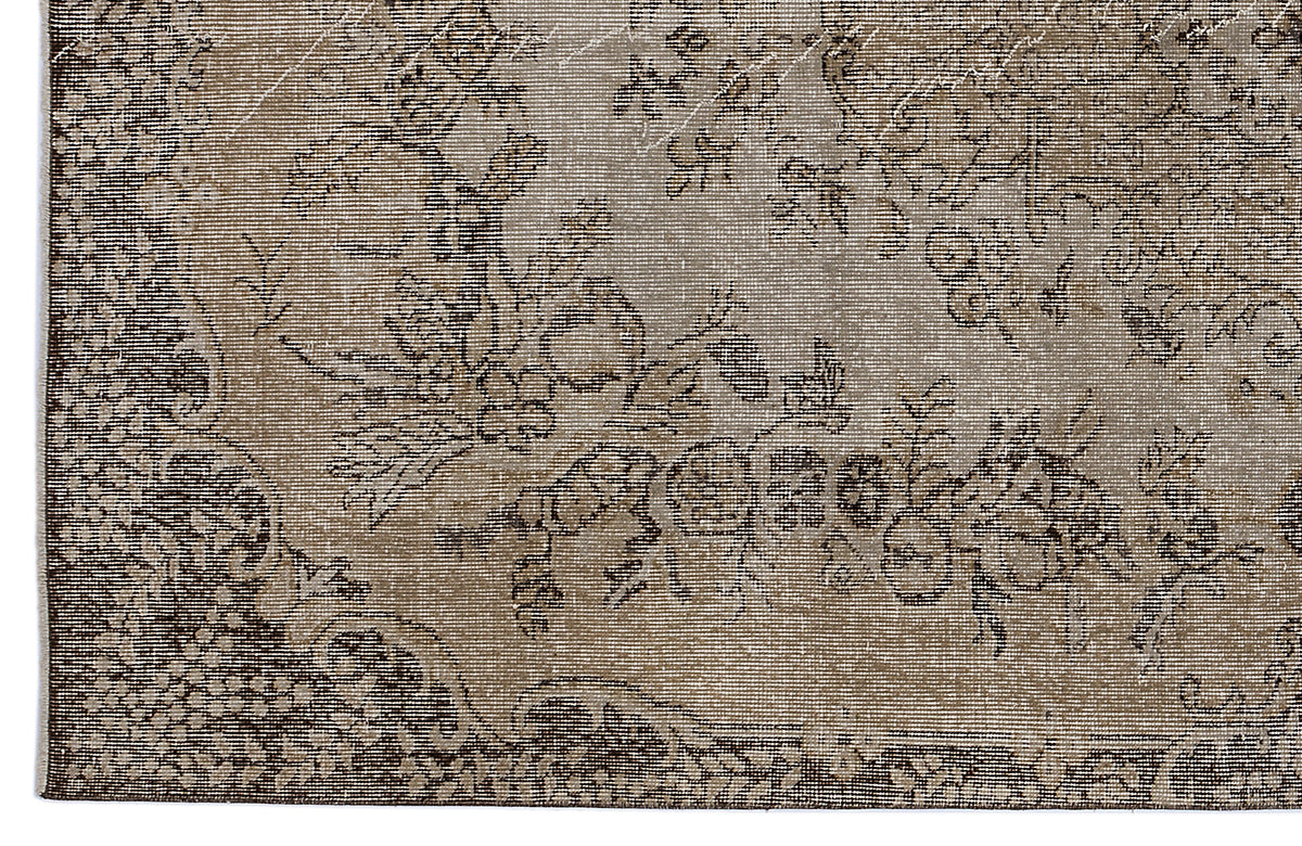 Taupe and dark brown vintage-style rug with a distressed floral medallion pattern.