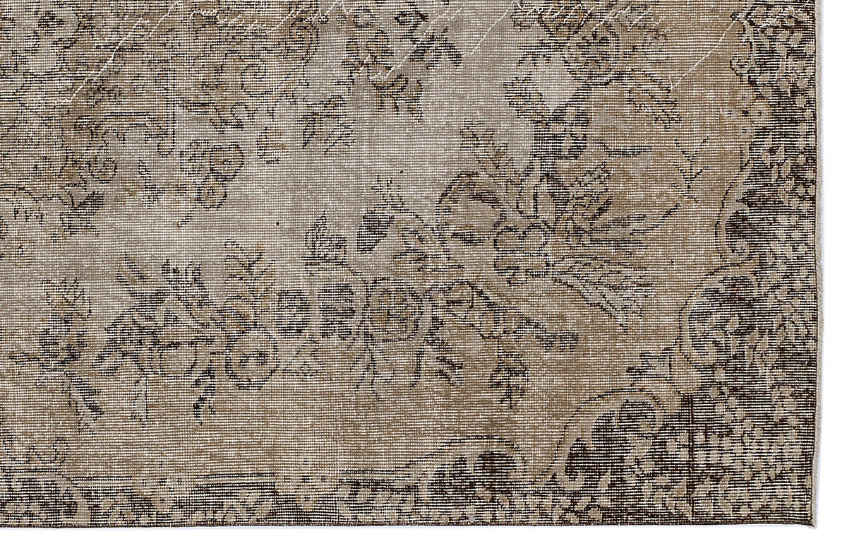 Distressed beige and dark brown rug with a faded floral medallion pattern.