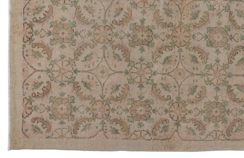 Load image 1 in gallery view. Beige and tan vintage-style rug with a repeating floral medallion pattern in muted green and brown tones.