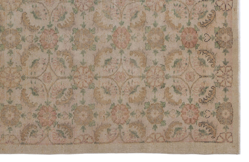 Load image 1 in gallery view. Beige rug with a faded floral medallion pattern in muted pink, green, and tan, featuring a geometric lattice border.