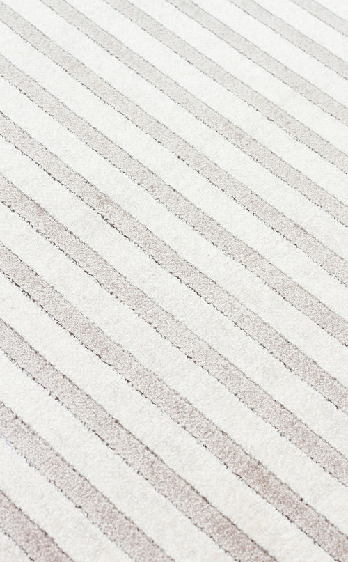 Load image 1 in gallery view. Off-white and light beige rug featuring a diagonal striped pattern with a textured, high-low pile.