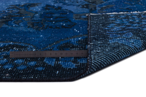 Load image 1 in gallery view. Deep blue and black distressed floral rug with a folded corner and a metal ruler for scale.