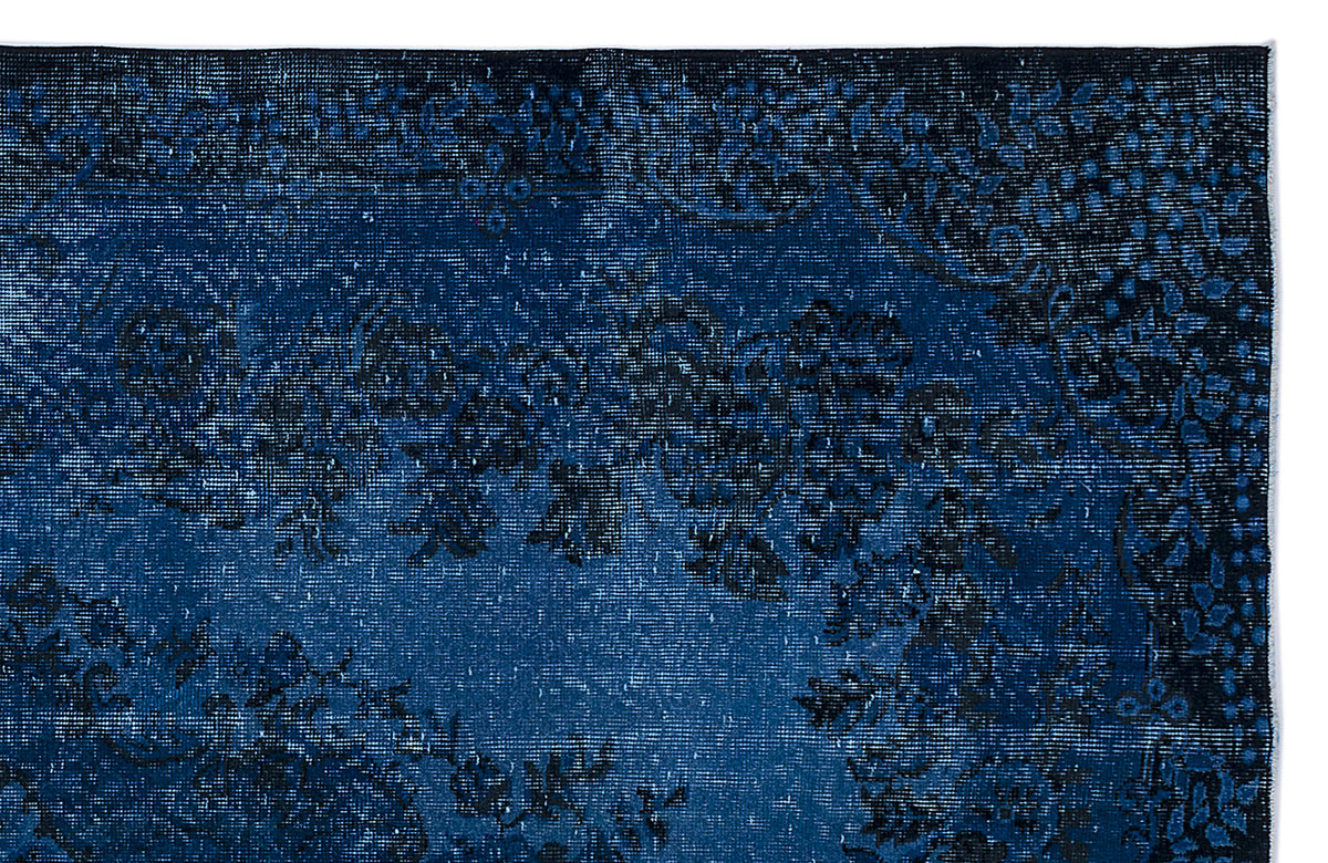 Deep blue and black distressed rug with a traditional floral medallion pattern.