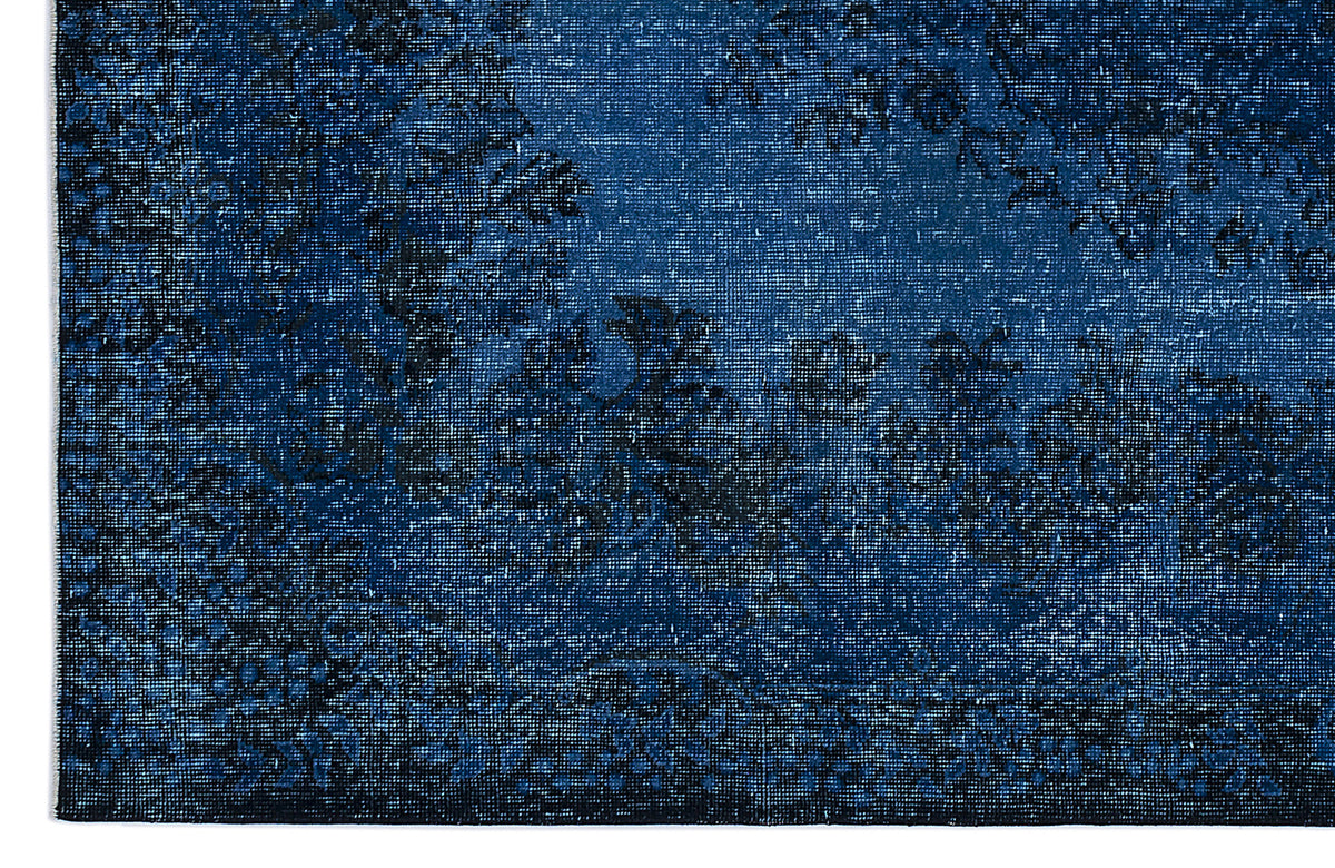Deep blue and black distressed rug with a faded traditional floral medallion pattern.