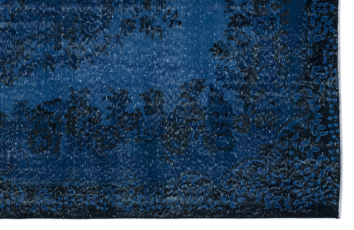 Deep blue and black distressed rug with a traditional floral medallion pattern.