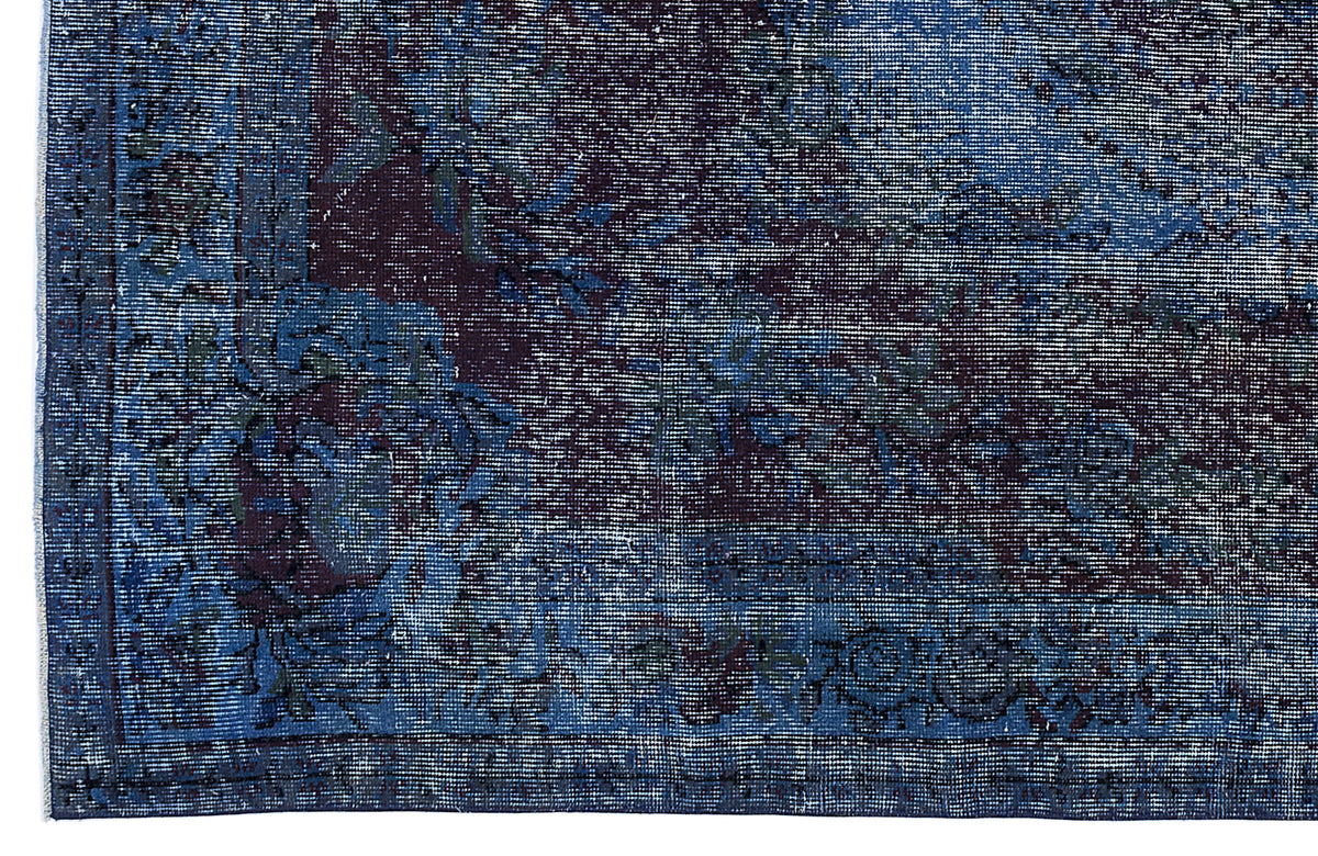 Deep blue and dark purple distressed rug with a traditional ornate floral medallion pattern.