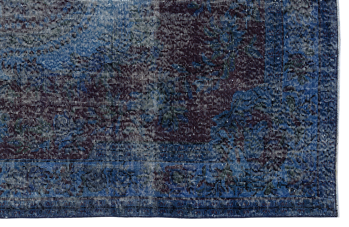 Deep blue and charcoal distressed rug with a traditional floral medallion pattern.