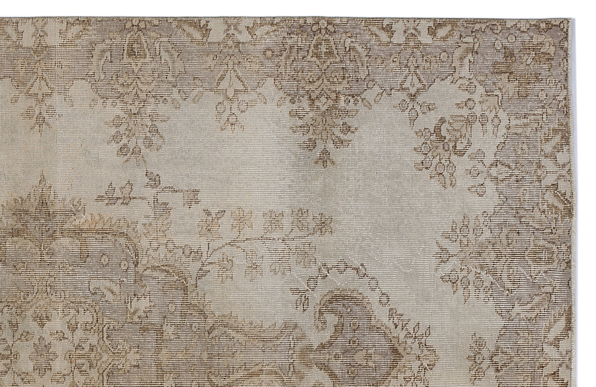 Beige and taupe distressed rug with a faded traditional floral medallion pattern.