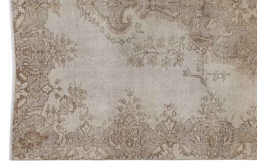 Load image 1 in gallery view. Beige and taupe vintage-style rug with a faded floral medallion pattern on a white background.
