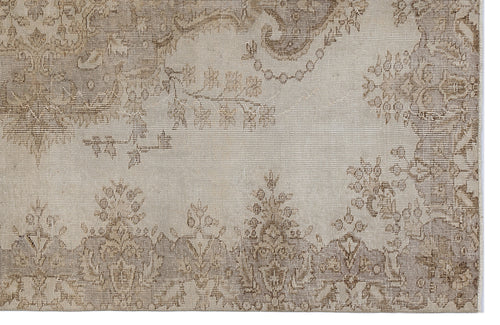 Load image 1 in gallery view. Beige and taupe rug with a faded, traditional floral medallion pattern and distressed texture.