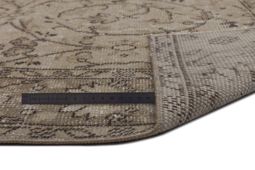 Load image 1 in gallery view. Beige and brown distressed traditional rug with a floral medallion pattern, shown with a metal ruler for scale.