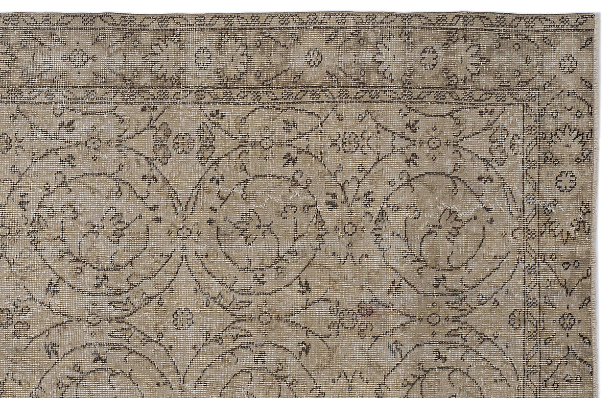Taupe and brown vintage-style rug with a distressed floral medallion pattern and a decorative border.