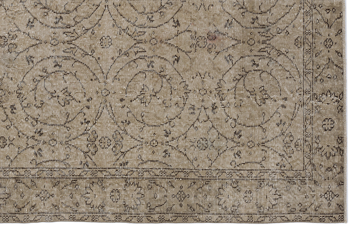 Taupe and brown vintage-style rug with a distressed floral medallion pattern and a decorative border.