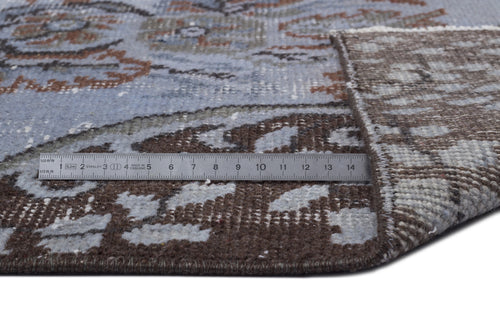 Load image 1 in gallery view. Blue and brown distressed traditional rug with a folded corner and a metal ruler for scale.