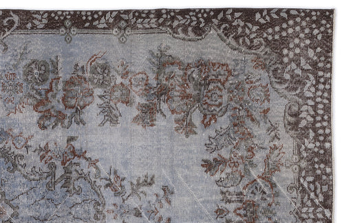 Load image 1 in gallery view. Distressed blue and brown rug with a traditional floral medallion pattern and a dark, intricate border.