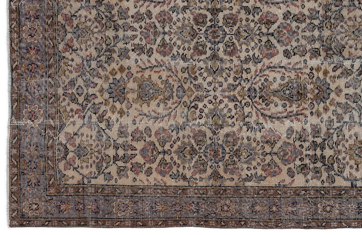 Beige and brown traditional rug with a distressed floral medallion pattern and a dark bordered edge.
