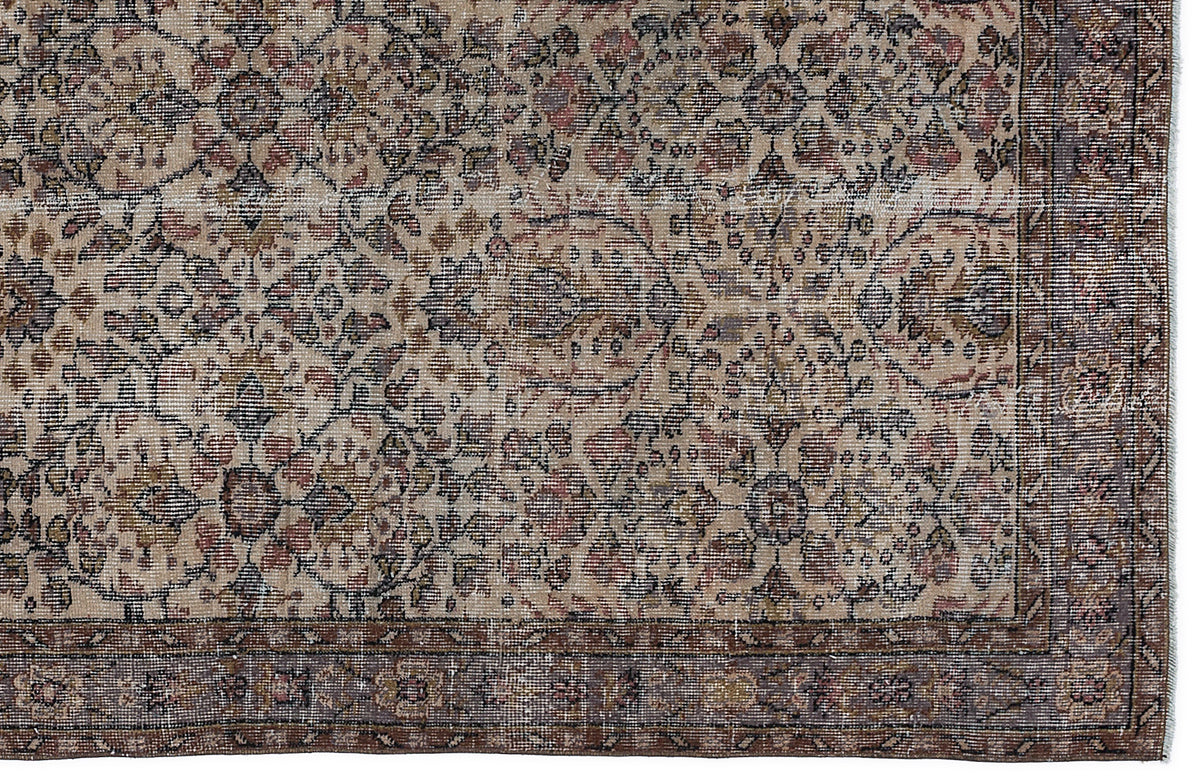 Distressed beige, brown, and muted red rug with a traditional floral medallion pattern and a wide decorative border.