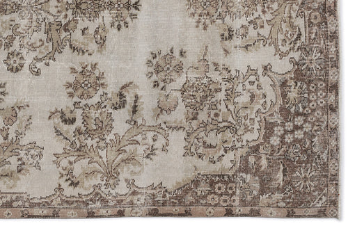 Load image 1 in gallery view. Beige and brown distressed rug with a faded floral medallion pattern on a white background.