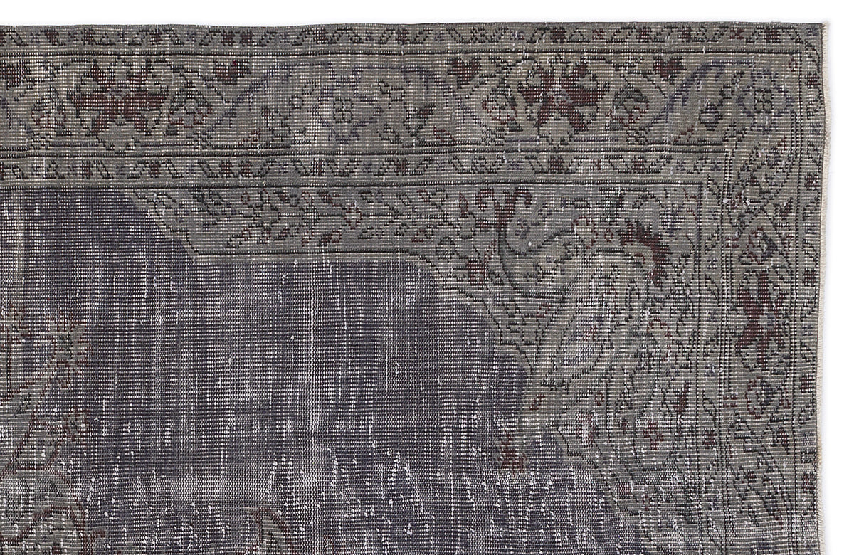 Charcoal and grey vintage-style rug with a distressed floral border and central medallion pattern.