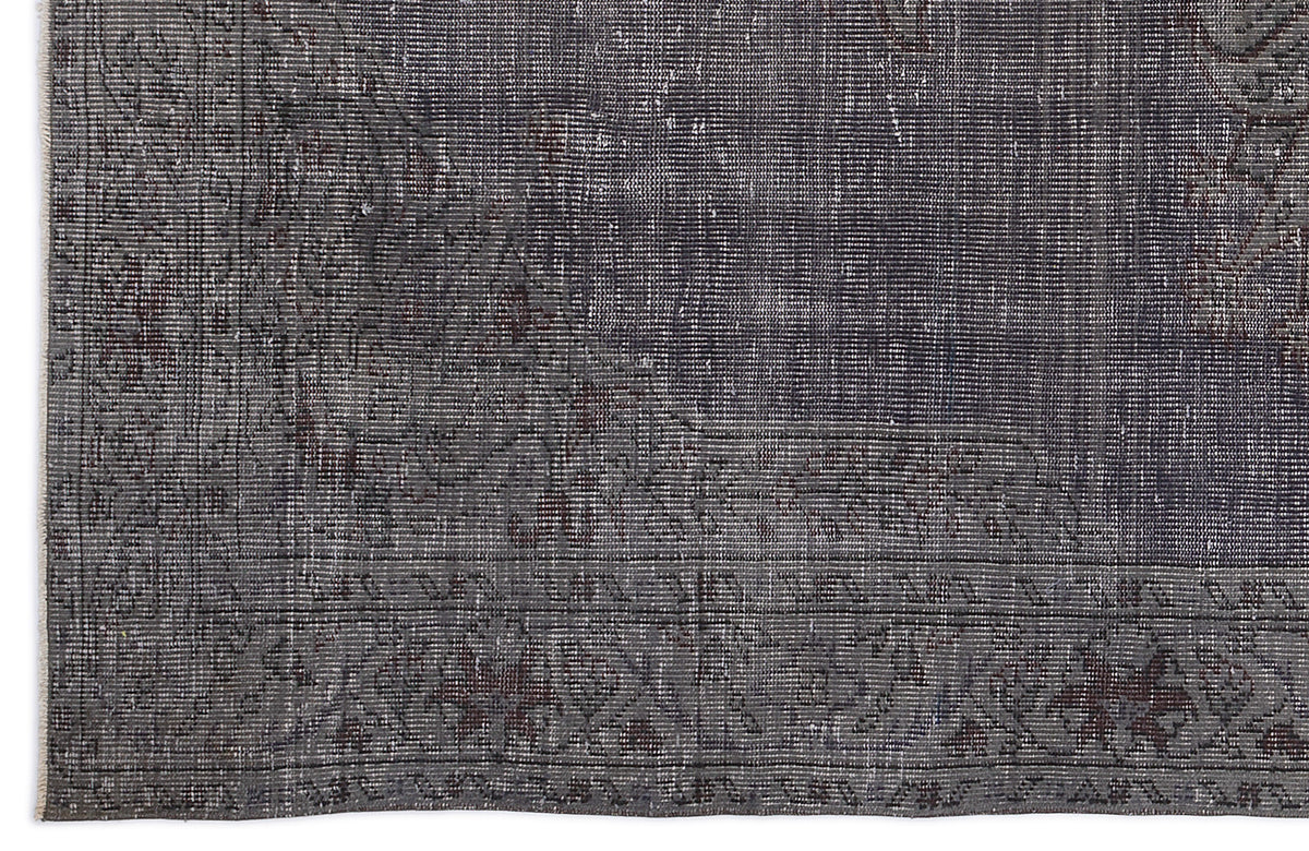 Charcoal and dark grey distressed rug with a faded traditional medallion pattern and a detailed geometric border.