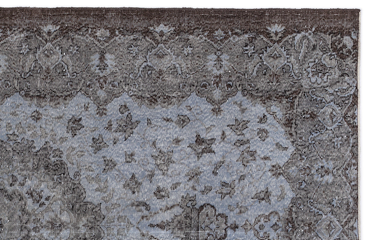 Dark brown and slate blue traditional rug with a distressed floral medallion pattern.