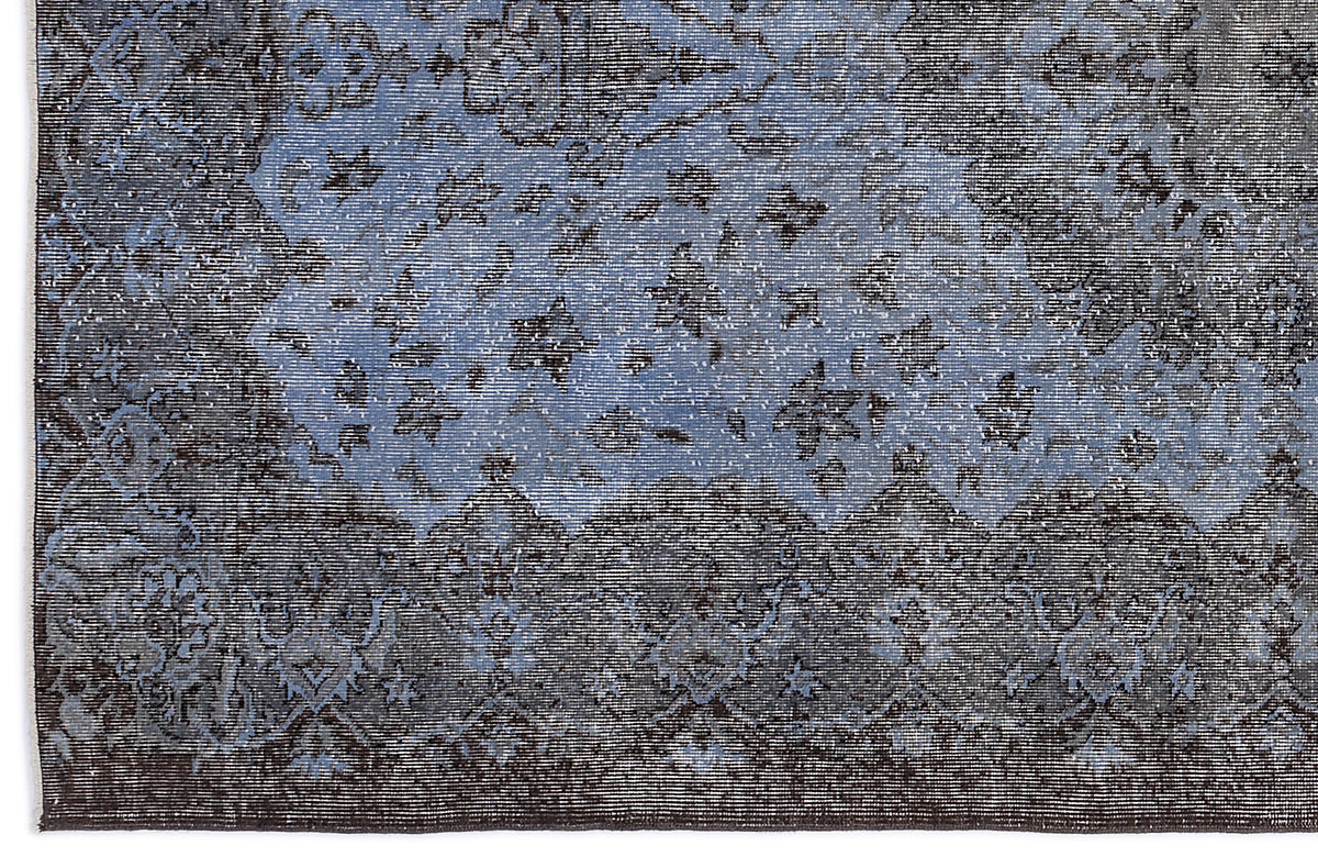 Dark blue and charcoal grey rug with a distressed, traditional floral medallion pattern.